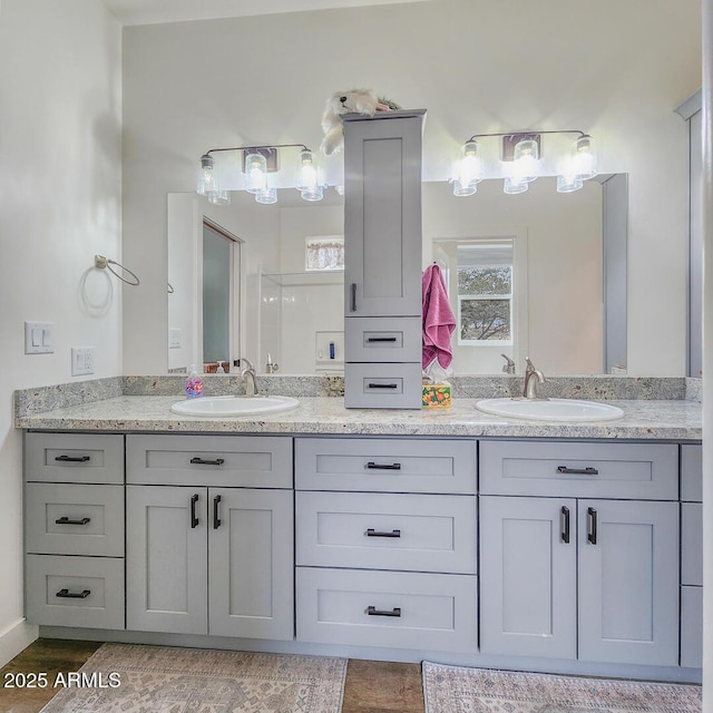 bathroom featuring a sink, a shower, and double vanity