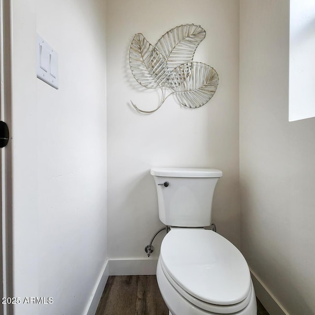 bathroom featuring toilet, wood finished floors, and baseboards