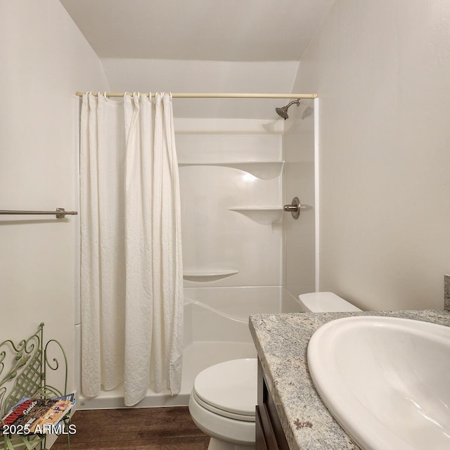 full bathroom featuring vanity, a shower with shower curtain, toilet, and wood finished floors