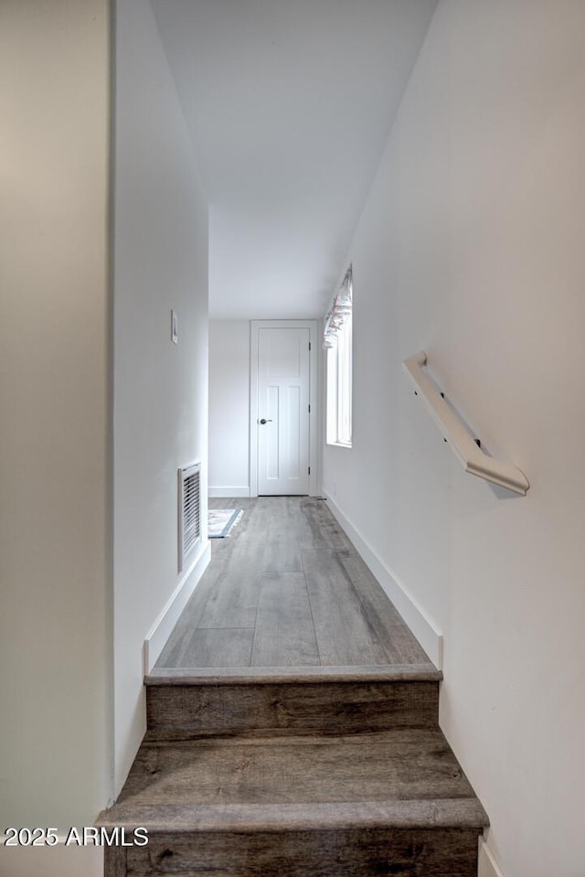 stairway featuring visible vents and baseboards