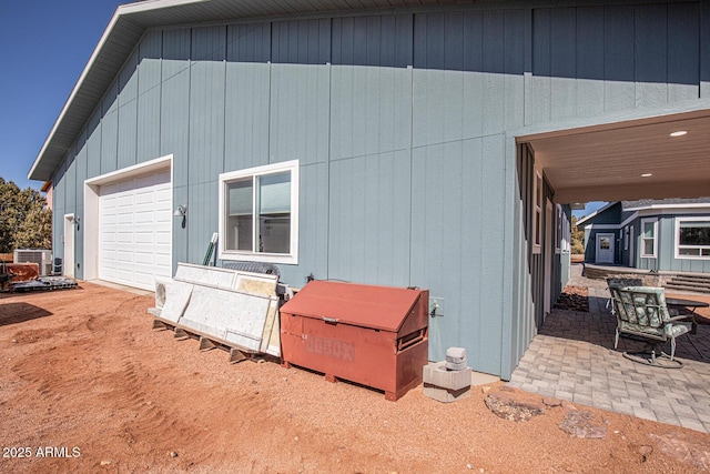 exterior space with central AC and a garage