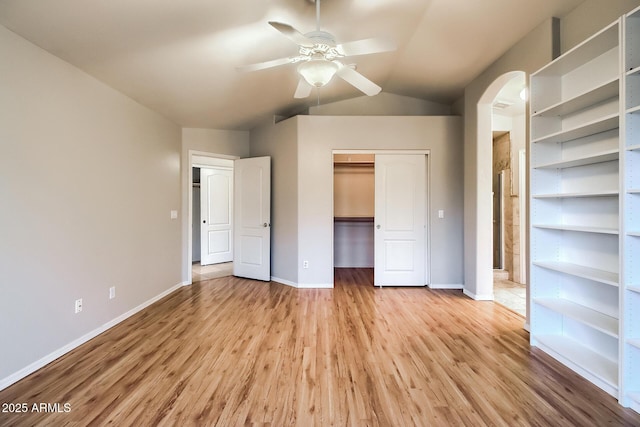 unfurnished bedroom with ceiling fan, a closet, vaulted ceiling, and light hardwood / wood-style flooring