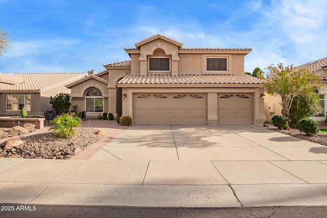 mediterranean / spanish-style home featuring concrete driveway, a tiled roof, a garage, and stucco siding