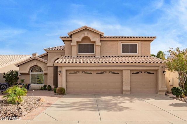 mediterranean / spanish home with a tiled roof, stucco siding, and driveway