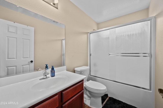 full bathroom featuring vanity, toilet, and shower / bath combination with glass door