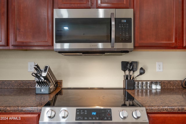 kitchen featuring stove and dark stone countertops