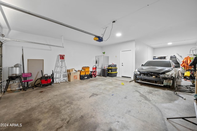 garage featuring stainless steel fridge and a garage door opener