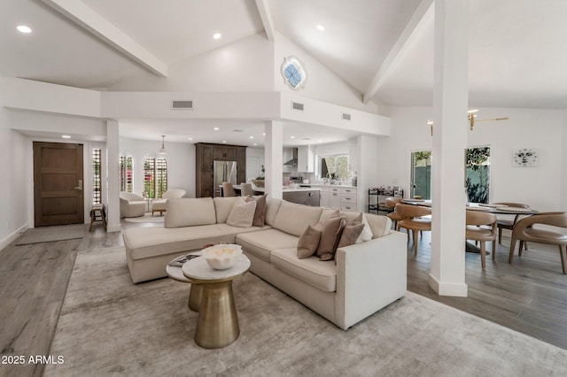 8719 E San Marino Dr, Scottsdale, AZ 85258 - living area featuring beamed ceiling, light wood-style flooring, visible vents, and a wealth of natural light