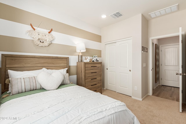 carpeted bedroom with a closet, visible vents, and baseboards