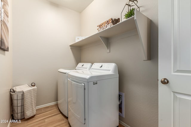 laundry area featuring light wood-type flooring, washer and dryer, laundry area, and baseboards