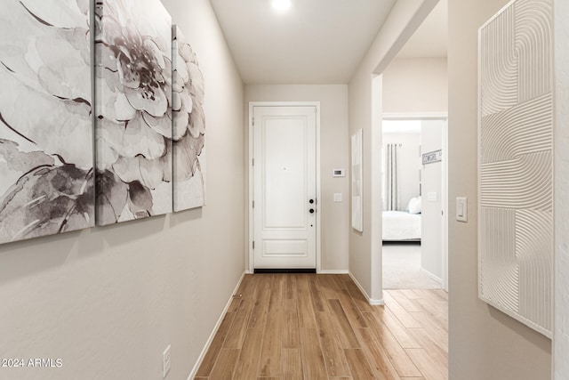 corridor featuring wood finished floors and baseboards