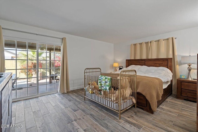 bedroom featuring access to exterior and wood finished floors