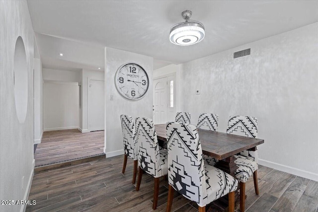 dining room with wood finished floors, visible vents, and baseboards