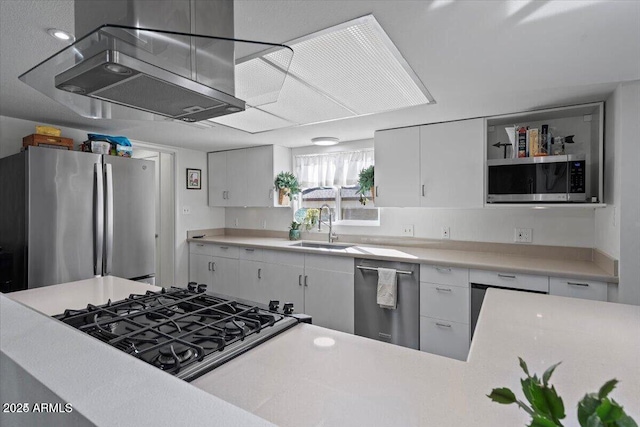 kitchen with white cabinets, stainless steel appliances, light countertops, and a sink