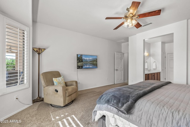 bedroom with ceiling fan, ensuite bathroom, and carpet floors