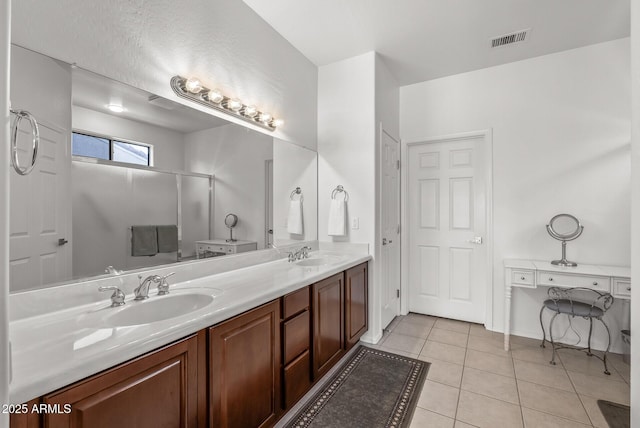 bathroom with an enclosed shower, vanity, and tile patterned floors