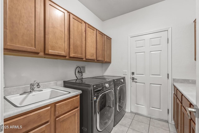 washroom featuring cabinets, sink, light tile patterned floors, and washer and dryer