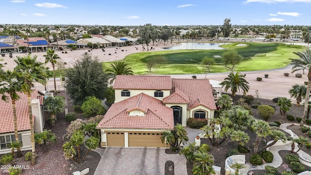 birds eye view of property with golf course view and a water view
