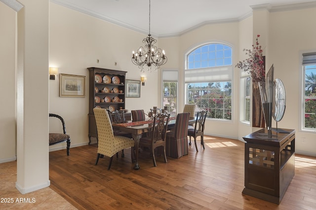 dining space featuring crown molding, wood finished floors, and baseboards