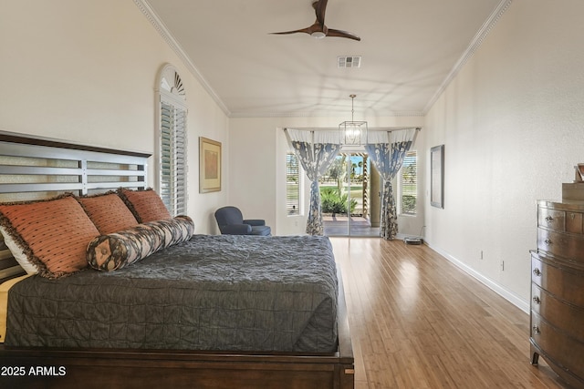 bedroom with visible vents, baseboards, ornamental molding, wood finished floors, and access to outside