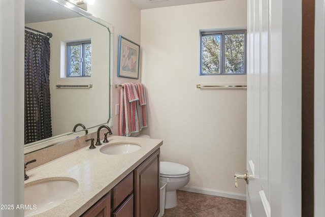 full bath featuring double vanity, toilet, baseboards, and a sink
