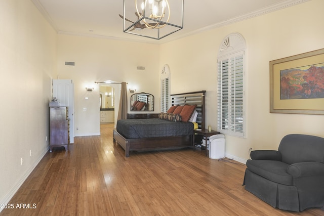bedroom featuring visible vents, wood finished floors, an inviting chandelier, crown molding, and baseboards
