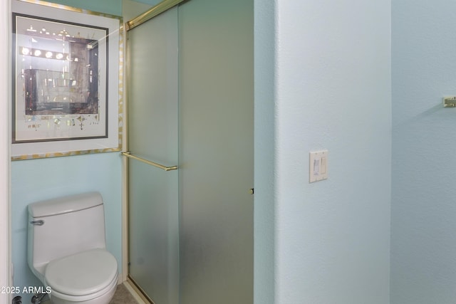 bathroom featuring a shower stall and toilet