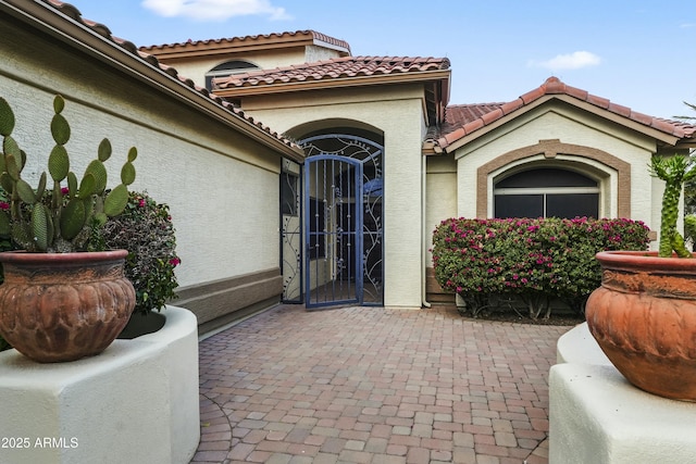 exterior space featuring stucco siding, a patio, and a tiled roof