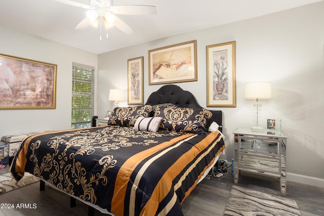 bedroom featuring a ceiling fan, baseboards, and wood finished floors