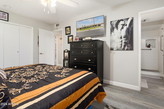 bedroom with hardwood / wood-style floors, a closet, ensuite bathroom, and ceiling fan