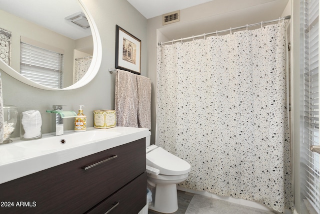 full bath with toilet, vanity, and visible vents