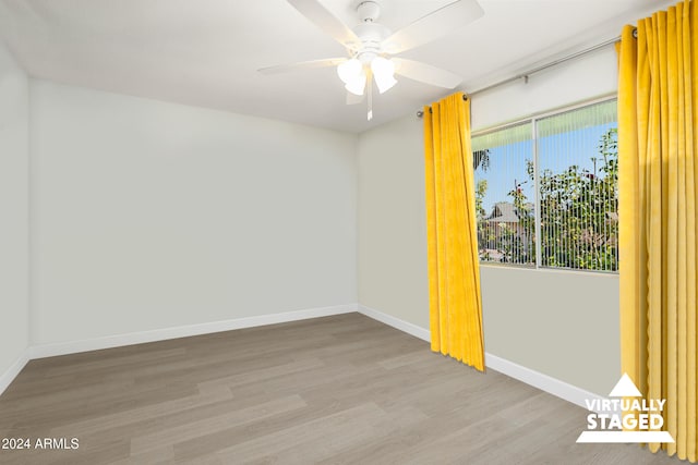 spare room with a ceiling fan, light wood-style flooring, and baseboards