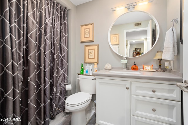 bathroom featuring wood-type flooring, vanity, toilet, and walk in shower