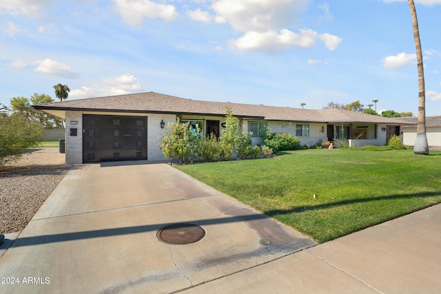 ranch-style home with a garage, driveway, brick siding, and a front yard