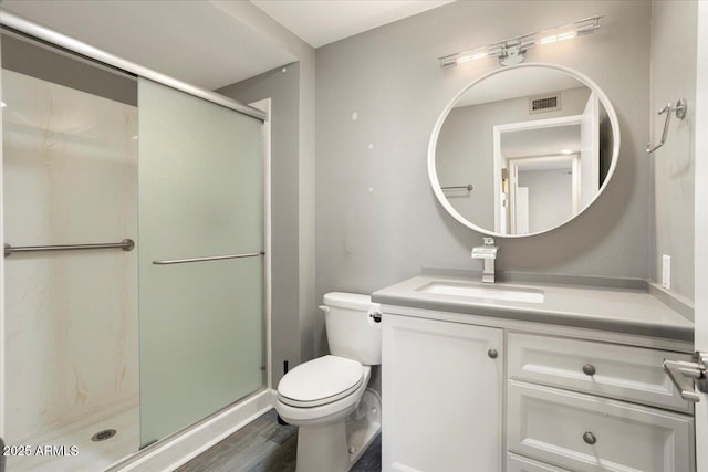 bathroom featuring toilet, a stall shower, vanity, and visible vents