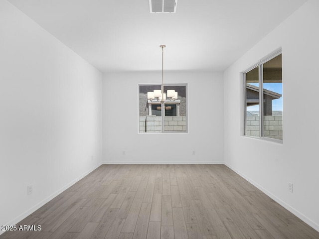 17815 W Denton Ave, Litchfield Park, AZ 85340 - unfurnished dining area featuring a chandelier, wood finished floors, and baseboards