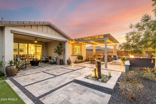 patio terrace at dusk with ceiling fan and a pergola