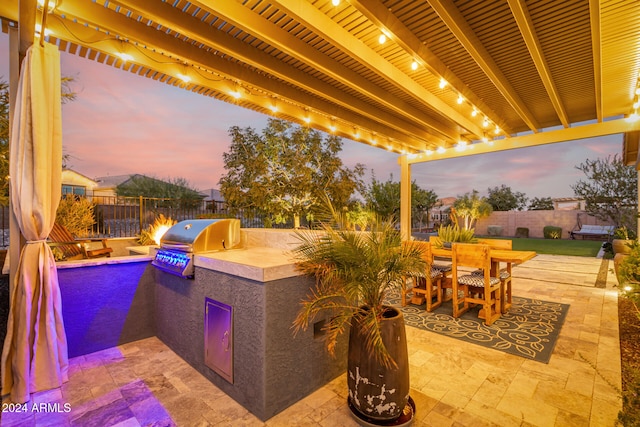 patio terrace at dusk with area for grilling and a grill