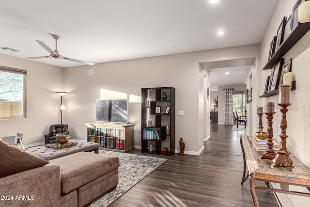 living room featuring dark wood-type flooring and ceiling fan