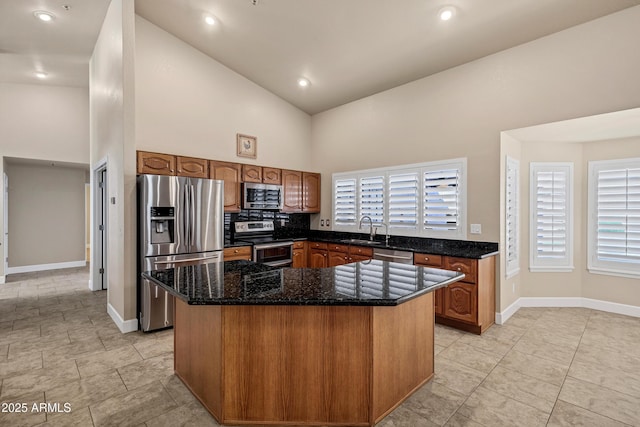 kitchen with high vaulted ceiling, sink, appliances with stainless steel finishes, and dark stone counters