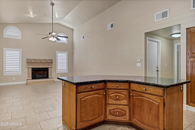 kitchen featuring ceiling fan, light tile patterned flooring, high vaulted ceiling, and a kitchen island