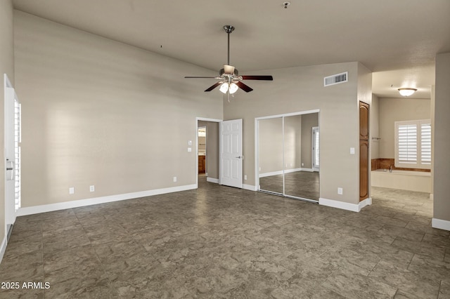 unfurnished bedroom featuring ceiling fan, connected bathroom, and vaulted ceiling