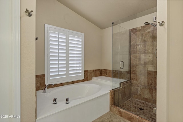 bathroom featuring independent shower and bath and vaulted ceiling