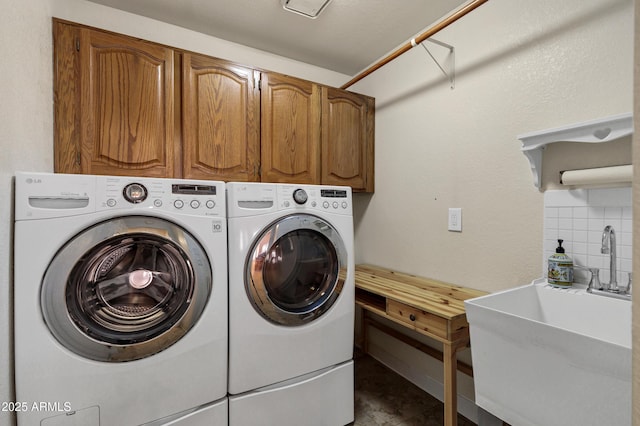 washroom featuring sink, cabinets, and washing machine and dryer