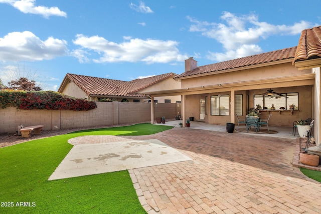 rear view of property featuring ceiling fan and a patio