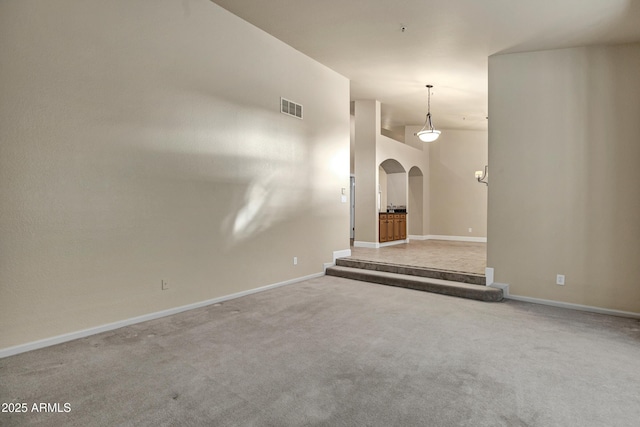 carpeted spare room with lofted ceiling