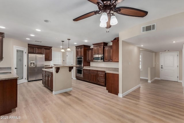 1535 E Kenwood St, Mesa, AZ 85203 - kitchen featuring stainless steel appliances, a ceiling fan, a kitchen breakfast bar, light wood-style flooring, and recessed lighting