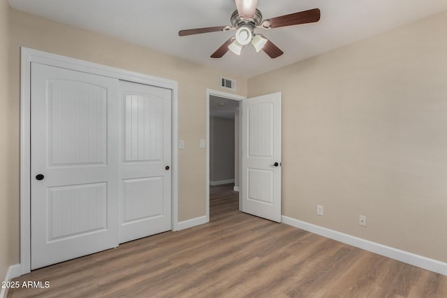 1535 E Kenwood St, Mesa, AZ 85203 - unfurnished bedroom featuring baseboards, wood finished floors, a closet, and a ceiling fan