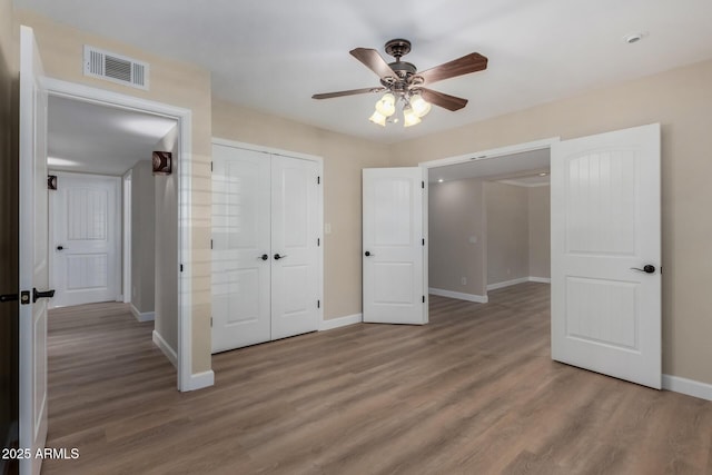 1535 E Kenwood St, Mesa, AZ 85203 - unfurnished bedroom with baseboards, wood finished floors, a closet, and ceiling fan