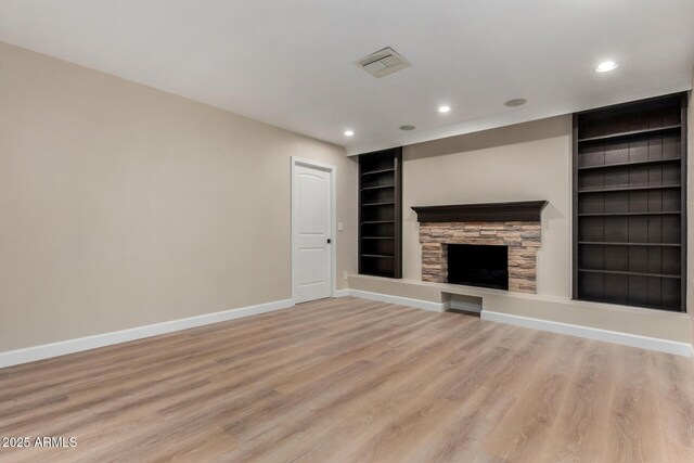 1535 E Kenwood St, Mesa, AZ 85203 - unfurnished living room featuring built in shelves, baseboards, light wood-style floors, a stone fireplace, and recessed lighting